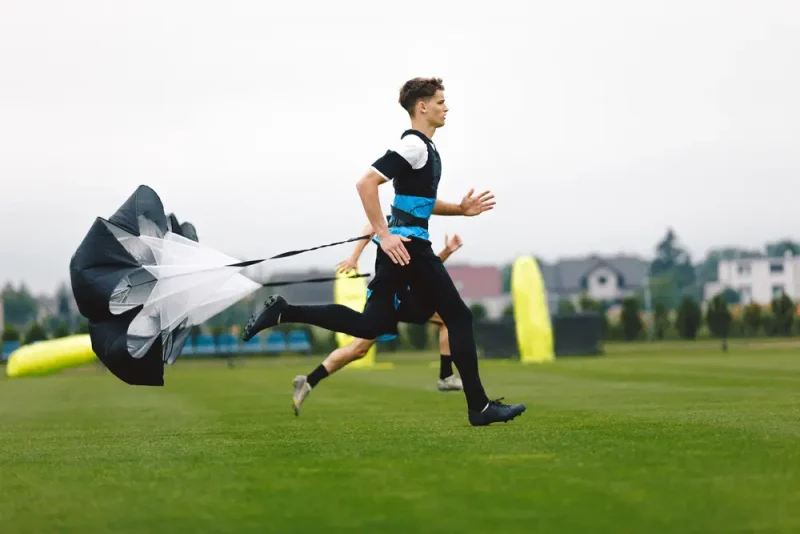 Preparación fíisica en fútbol - Jugador corriendo con paracaídas
